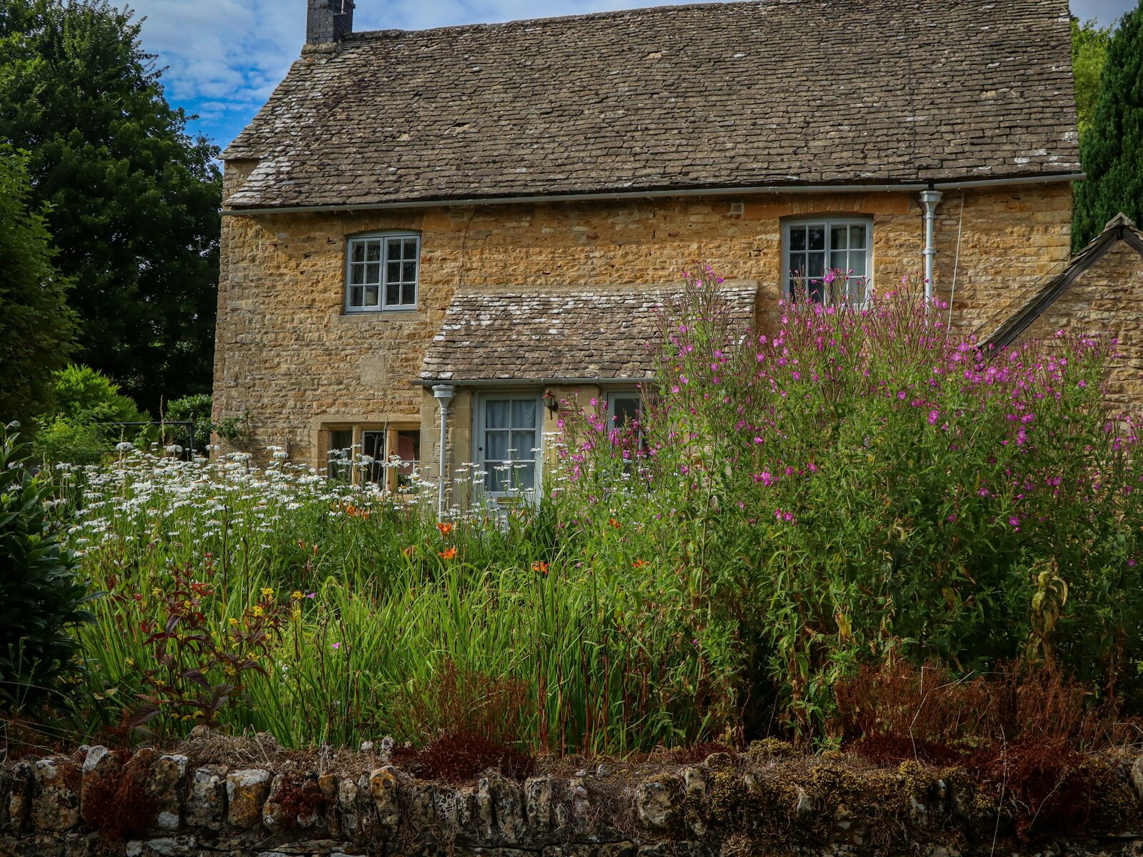 The stone exterior of Sage House with its garden
